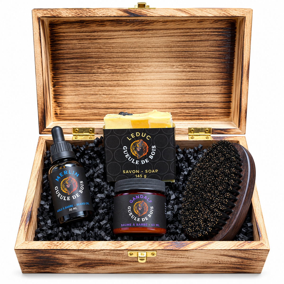 Coffret de bois brûlé ouvert avec une huile, un baume, un savon et une brosse à barbe Gueule de Bois